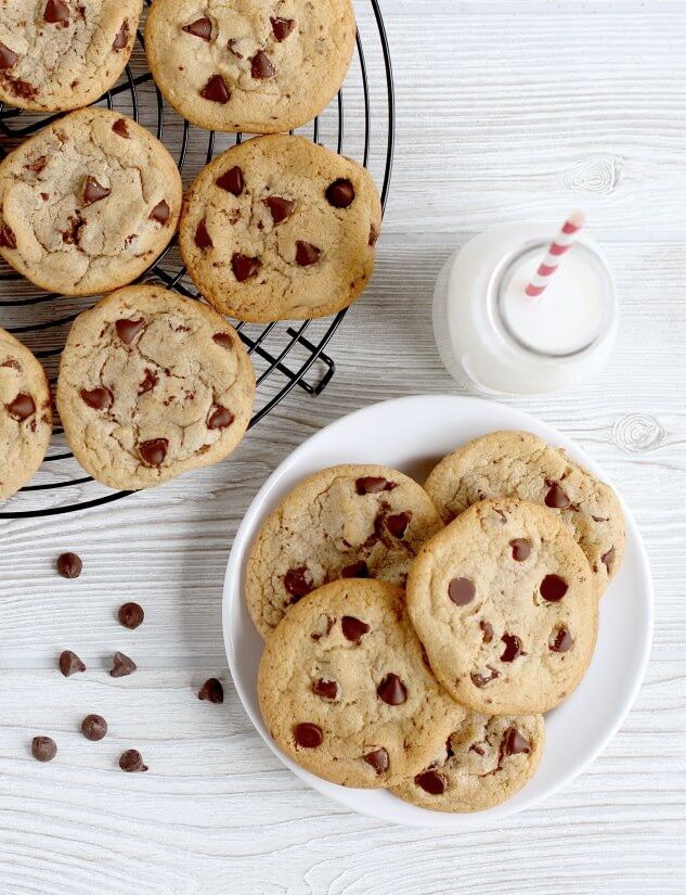 Chocolate Chip cookies on cooling rack and plate with glass of milk