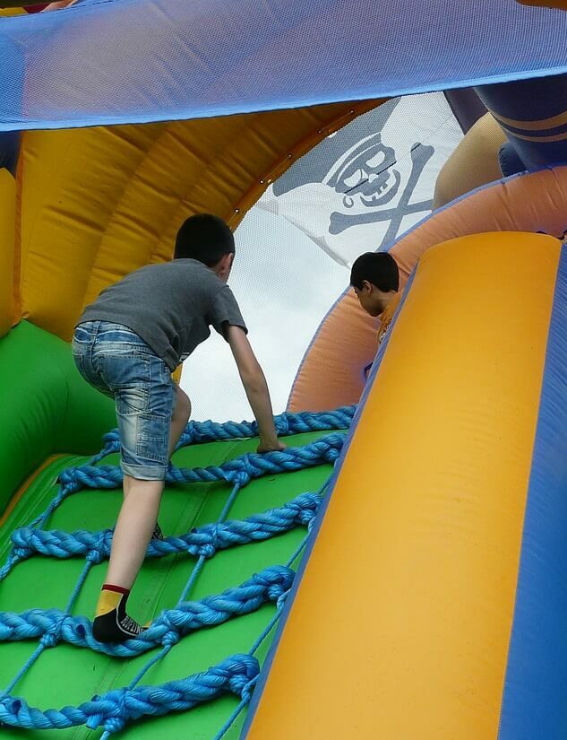 Kids playing on bouncy castle obstacle course