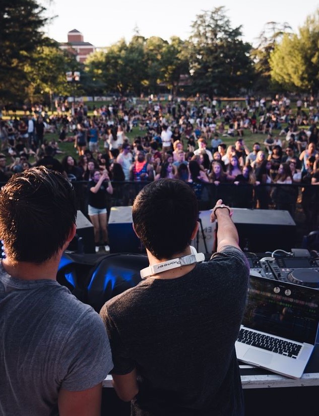 Picture of a DJ in front of a large crowd outside